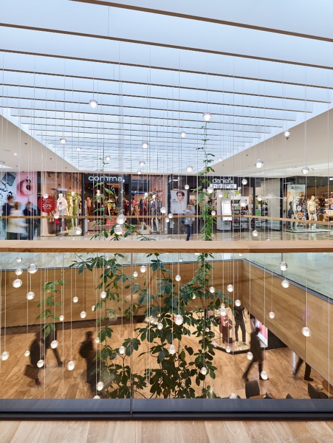 Lichthof mit vielen kleinen Lampen und Pflanzen - Eingang Comma Store